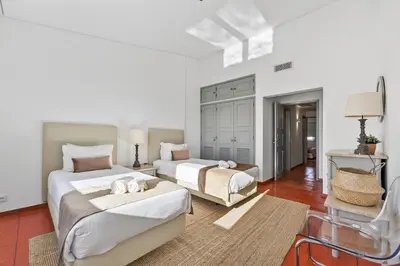 a white bedroom with a large bed and a large window at Casa Mimosa in Vale do Lobo