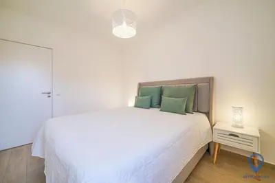 a bedroom with a large white bed with green pillows at Bordalo by MTPhomes in Albufeira