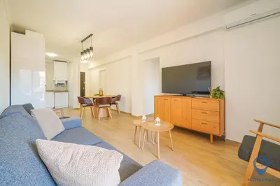 a living room with a blue couch and a tv at Bordalo by MTPhomes in Albufeira
