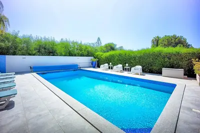 a swimming pool with blue water in a yard at Zen Balaia in Olhos de Água