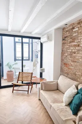 a living room with a couch and a brick wall at Elegant City Center Loft in Faro