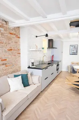 a living room with a couch and a kitchen at Elegant City Center Loft in Faro