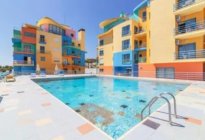 a swimming pool in front of two apartment buildings at Marina Heaven TatiHomes RC in Albufeira