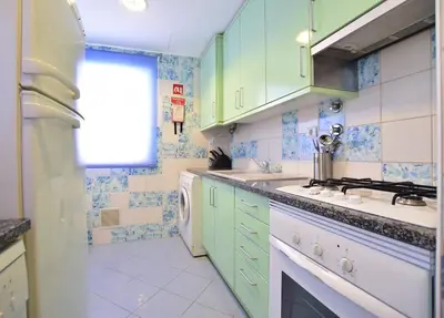 a kitchen with green cabinets and a stove top oven at Marina Heaven TatiHomes RC in Albufeira