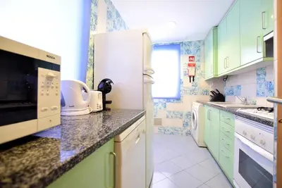 a kitchen with green cabinets and white appliances at Marina Heaven TatiHomes RC in Albufeira