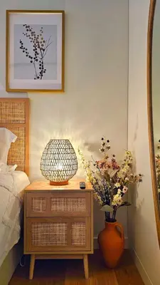 a bedroom with a table with a lamp and flowers on it at Sweet Horizon in Quarteira
