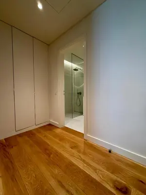 an empty room with white walls and wooden floors at Horizon Sand Beachfront apartment - Pool View, Quarteira in Bicas
