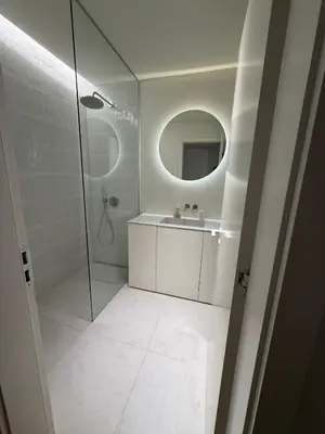 a bathroom with a shower and a sink and a mirror at Horizon Sand Beachfront apartment - Pool View, Quarteira in Bicas