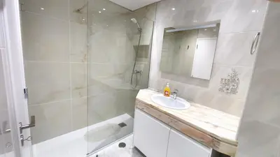 a white bathroom with a sink and a shower at Linda Vista in Albufeira