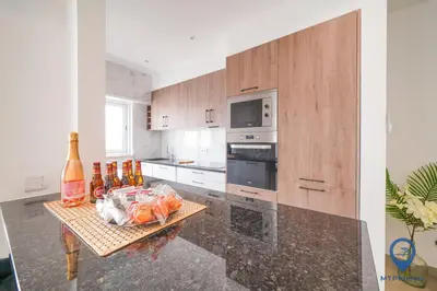 a kitchen with a table with bottles on it at Palmeiras by MTPhomes in Albufeira