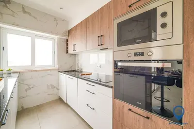 a kitchen with a stove and a microwave at Palmeiras by MTPhomes in Albufeira
