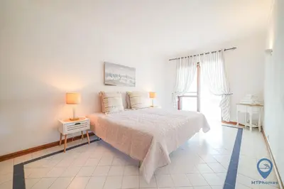 a white bedroom with a bed and a window at Salgados by MTPhomes in Guia