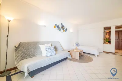 a white bedroom with a bed and a lamp at Salgados by MTPhomes in Guia