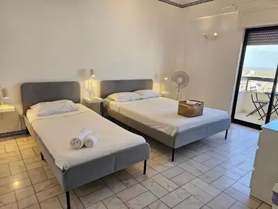 two beds in a room with a balcony at Blife Chelsya private apartment in Faro
