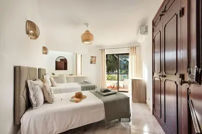 a bedroom with two beds and a large window at Pinhal View in Vilamoura