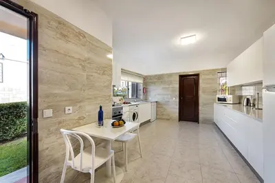 a kitchen with a white table and chairs in a room at Pinhal View in Vilamoura