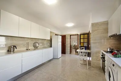 a kitchen with white cabinets and a white refrigerator at Pinhal View in Vilamoura