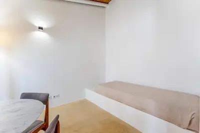 a small room with a bed and a desk at Uma Casa Rural in Santa Bárbara de Nexe