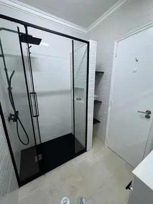 a shower with a glass door in a bathroom at Algarve, cozy T1plus1 apartment in the centre of Quarteira in Quarteira