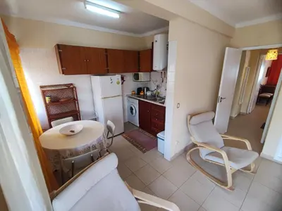 a small kitchen with a table and a chair in it at Algarve, cozy T1plus1 apartment in the centre of Quarteira in Quarteira