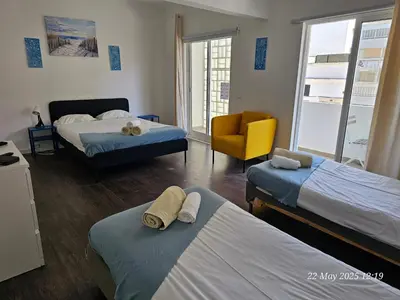 a bedroom with a bed and a yellow couch at Blife Farensya private apartment in Faro