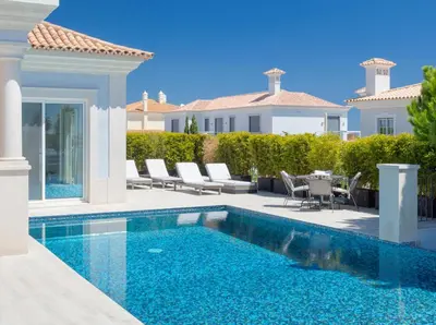 a swimming pool in front of a villa at Stunning home with nice pool close to the beach in Loulé