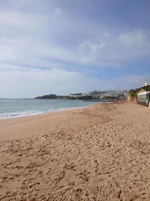 a beach with footprints in the sand and the ocean at Casa Donis 2021 in Albufeira