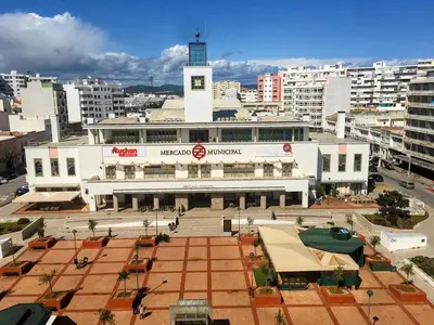 a large white building with a clock tower in a city at Apartamento T2 Moderno no Centro de Faro - ML - Market Tower in Faro