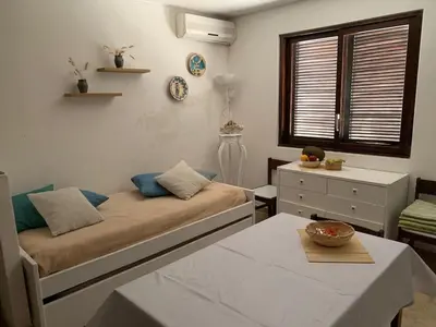 a living room with a bed and a table at Casa Oura Praia located 100 metres from the beach in Albufeira