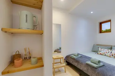 a small bedroom with a bed and a small table at AÇOTEIAS BEACH STUDIO - 5 min to Falesia Beach in Albufeira