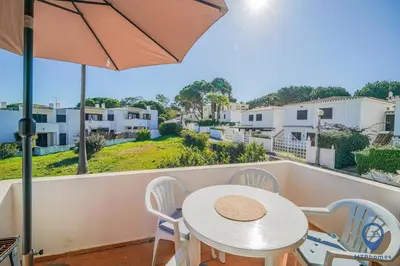 a white table and chairs on a balcony with an umbrella at Balaia Mar 63D By MTPhomes in Albufeira