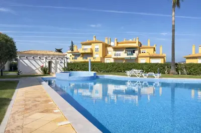 a large swimming pool in front of a house at Apartamento Terraços do Vale in Albufeira