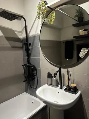 a bathroom with a sink and a mirror and a tub at Beach Holiday House T1 in Quarteira