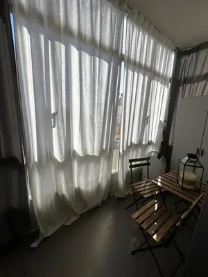 a room with a large window with white curtains at Beach Holiday House T1 in Quarteira