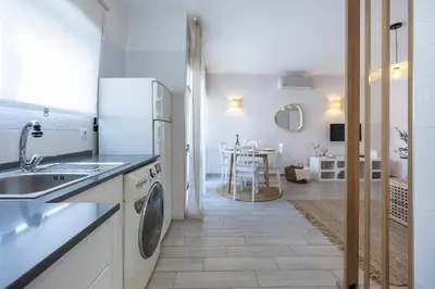 a white kitchen with a sink and a dishwasher at Albufeira City Centre Apartment with Pool in Albufeira