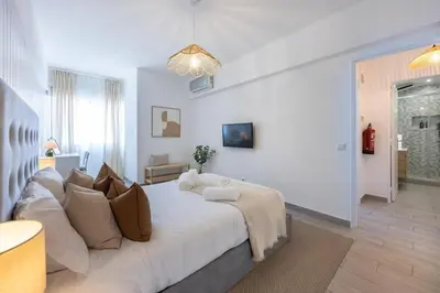 a white bedroom with a large bed in a room at Albufeira City Centre Apartment with Pool in Albufeira