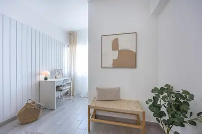 a living room with a table and a chair and a desk at Albufeira City Centre Apartment with Pool in Albufeira
