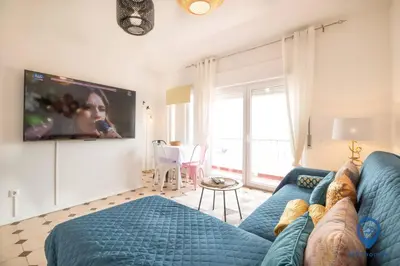 a living room with a blue couch and a tv at Eva Andorinha 2 Pax by MTPhomes in Ferreiras