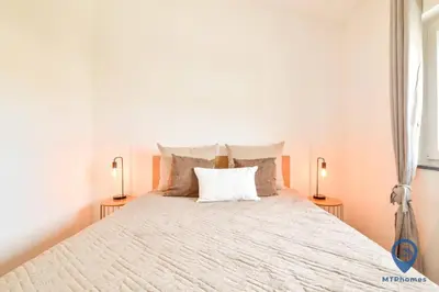 a bedroom with a large bed with two lamps at Eva Andorinha 2 Pax by MTPhomes in Ferreiras
