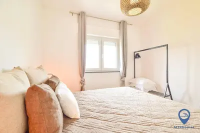 a bedroom with a large bed and a window at Eva Andorinha 2 Pax by MTPhomes in Ferreiras
