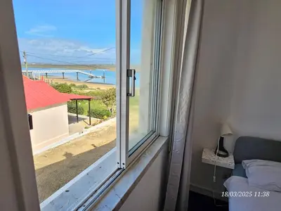 a room with a window with a view of a beach at Blife Faya private apartment in FAO