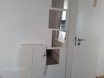 a small kitchen with a white refrigerator and a door at Blife Faya private apartment in FAO