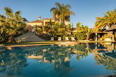 a house with palm trees and a swimming pool at Vistas Algarve in Loulé