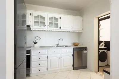 a white kitchen with a sink and a dishwasher at Dunas - Sea view near the beach by HD in Quarteira