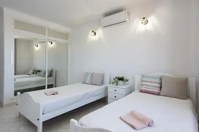 two beds in a white room with a mirror at Dunas - Sea view near the beach by HD in Quarteira