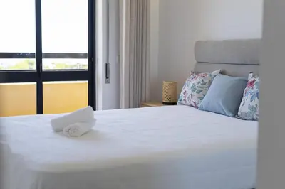 a white bed with a white towel on it at Dunas - Sea view near the beach by HD in Quarteira