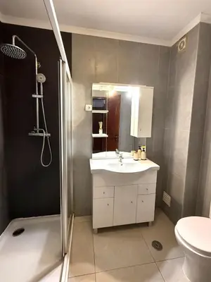 a bathroom with a sink and a shower and a toilet at Majesti Algarve Apartment in Albufeira