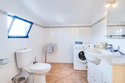 a kitchen with orange cabinets and a sink and a window at Duplex Apartment with Pool, Balcony, Wi-Fi & AC in Vilamoura