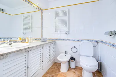 a kitchen with wooden cabinets and a sink and a window at Duplex Apartment with Pool, Balcony, Wi-Fi & AC in Vilamoura