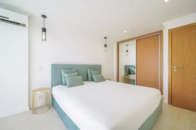 a bedroom with a large white bed with blue pillows at Coral by MTPhomes in Albufeira